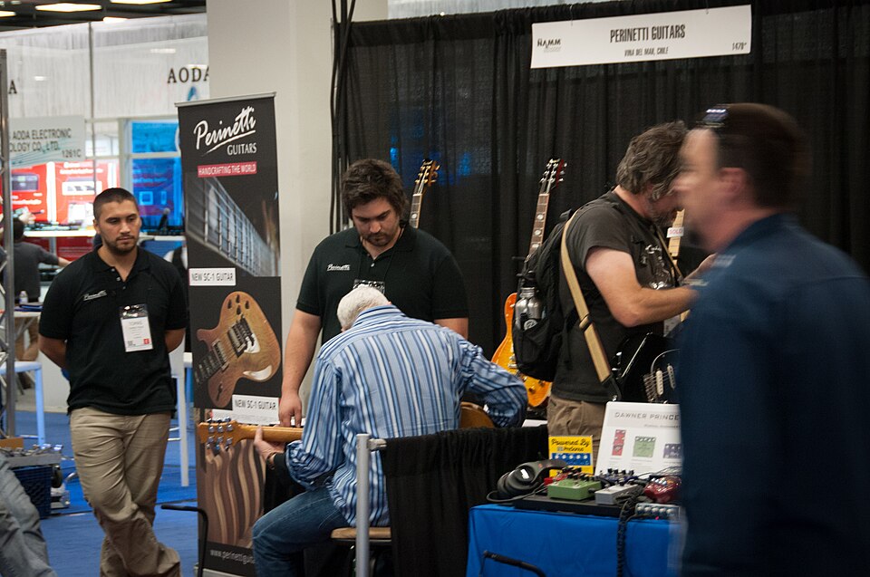 Paul Reed Smith checking out a Perinetti guitar - 2014 NAMM Show.jpg